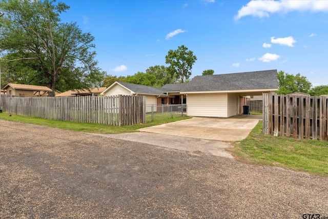 ranch-style home featuring driveway, fence private yard, and a carport