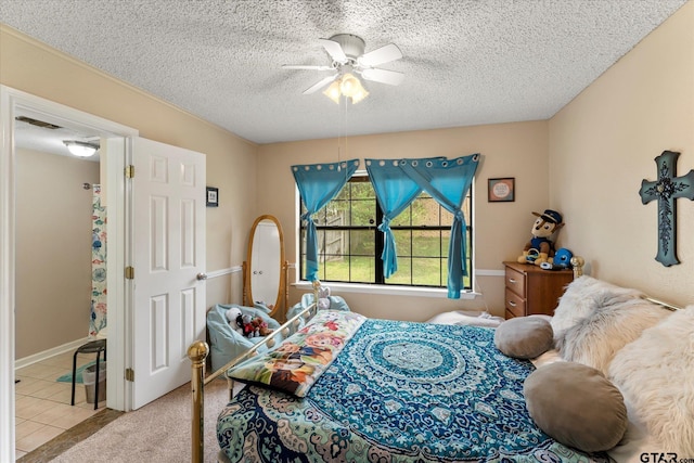 carpeted bedroom with a ceiling fan, tile patterned flooring, and a textured ceiling