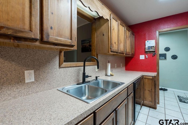 kitchen featuring dishwasher, light countertops, light tile patterned floors, a sink, and backsplash