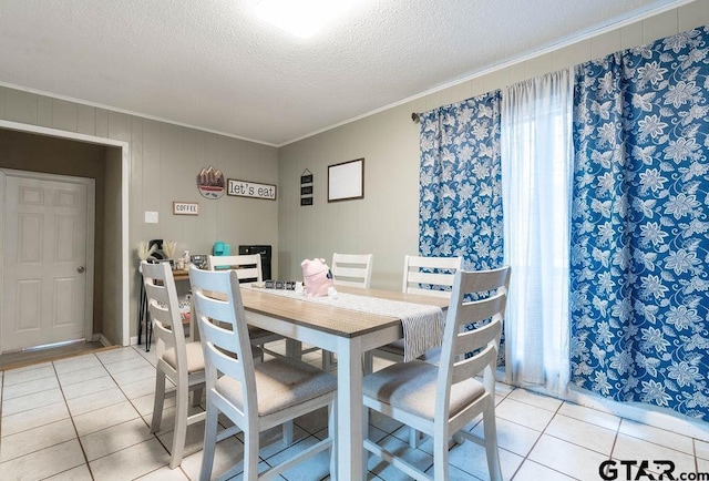 dining room with crown molding, light tile patterned flooring, and a textured ceiling