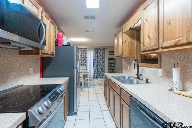 kitchen with light countertops, stainless steel appliances, visible vents, and a sink