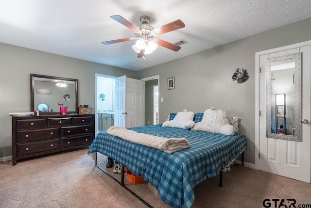 bedroom with visible vents, baseboards, ceiling fan, light colored carpet, and connected bathroom
