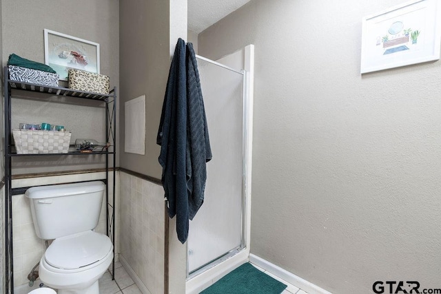 full bath featuring tile patterned flooring, toilet, and a shower stall