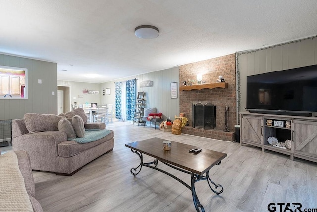 living room featuring a brick fireplace, wooden walls, and light wood-style flooring