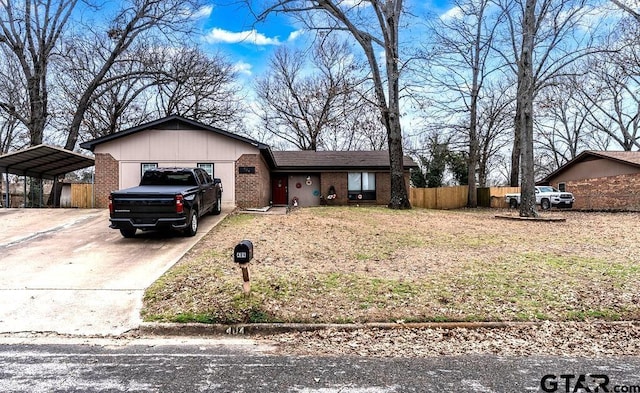 ranch-style house featuring concrete driveway, brick siding, fence, and a carport