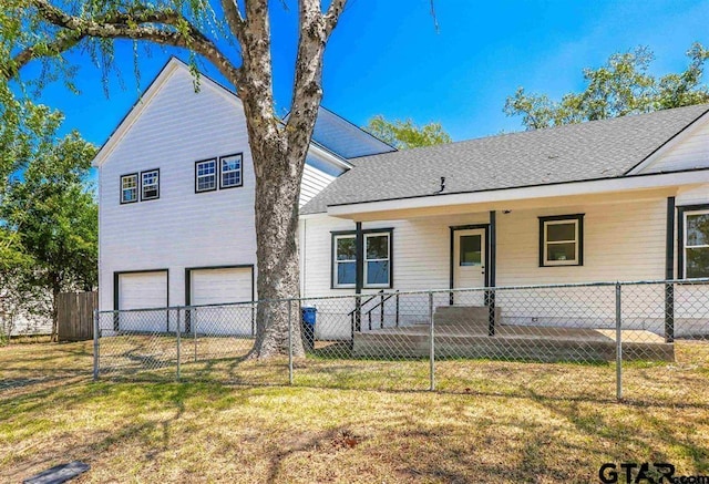 view of front of house featuring covered porch, a front yard, and a garage