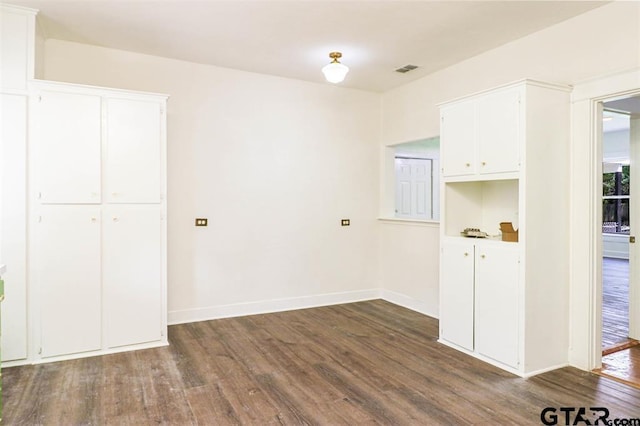 interior space featuring dark hardwood / wood-style floors and white cabinetry