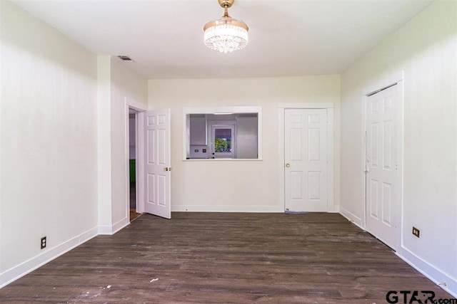 hallway with dark hardwood / wood-style flooring and a chandelier