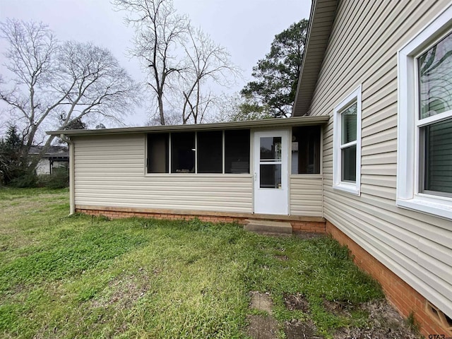 doorway to property with a lawn
