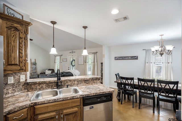 kitchen with a notable chandelier, hanging light fixtures, sink, dishwasher, and lofted ceiling