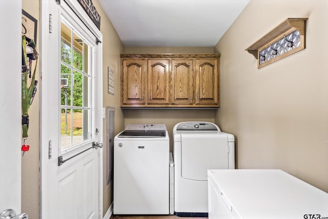 clothes washing area featuring a wealth of natural light, cabinets, and washing machine and clothes dryer