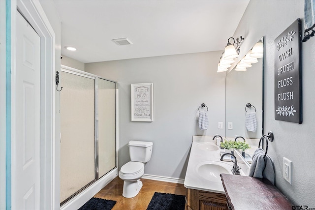 bathroom featuring vanity, hardwood / wood-style flooring, toilet, and a shower with door