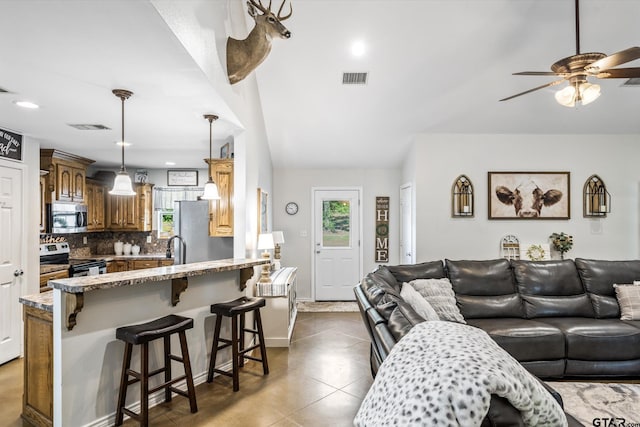 living room with sink, ceiling fan, light tile patterned floors, and vaulted ceiling