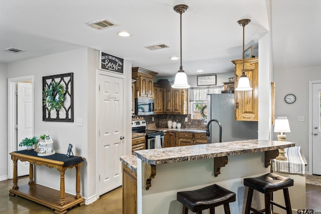 kitchen with kitchen peninsula, decorative backsplash, hanging light fixtures, a kitchen breakfast bar, and appliances with stainless steel finishes