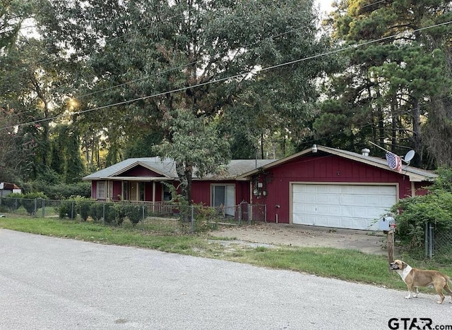 single story home with an attached garage, board and batten siding, and fence