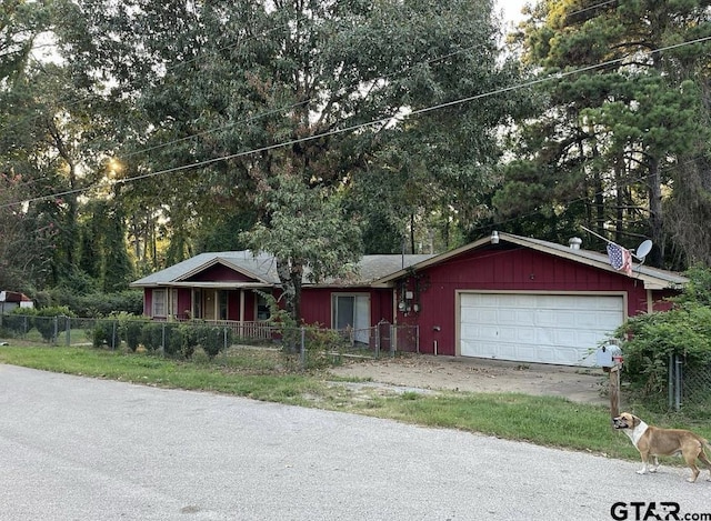 ranch-style house featuring an attached garage and fence