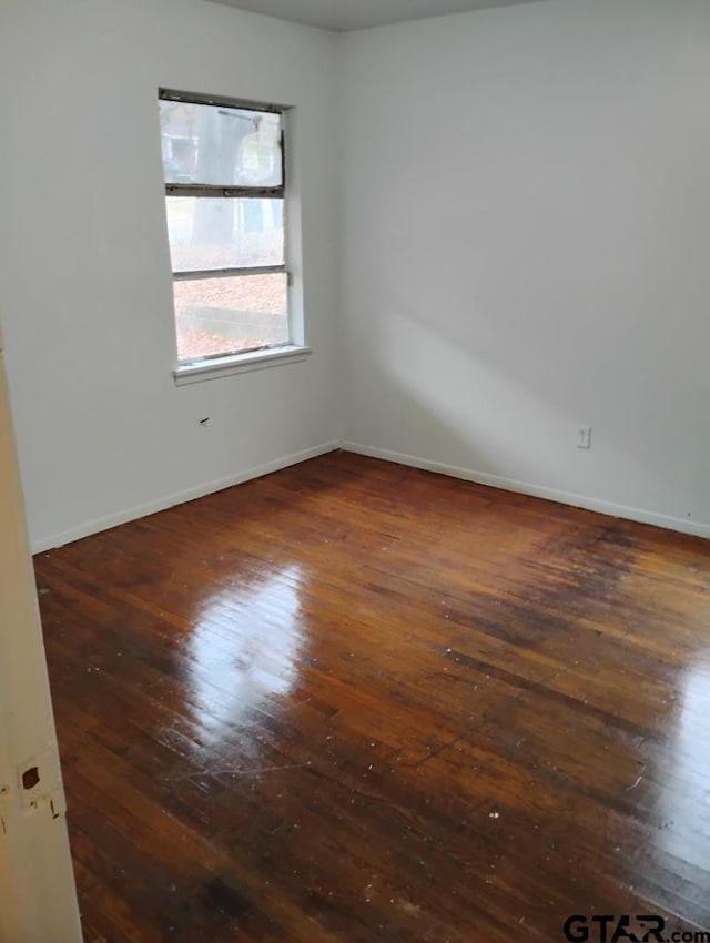 unfurnished room with dark hardwood / wood-style flooring