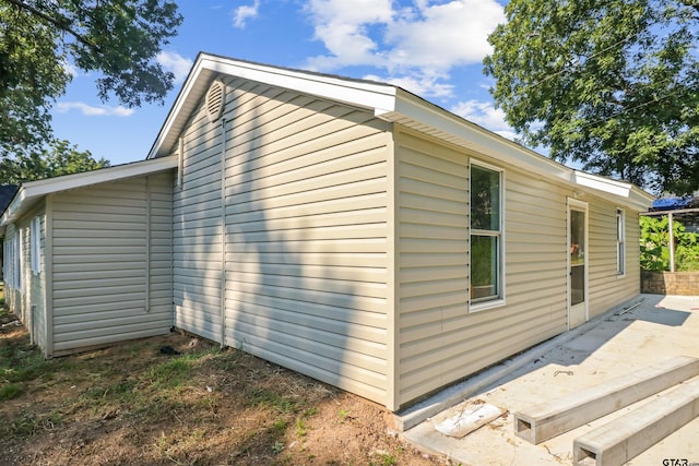 view of property exterior with a patio area