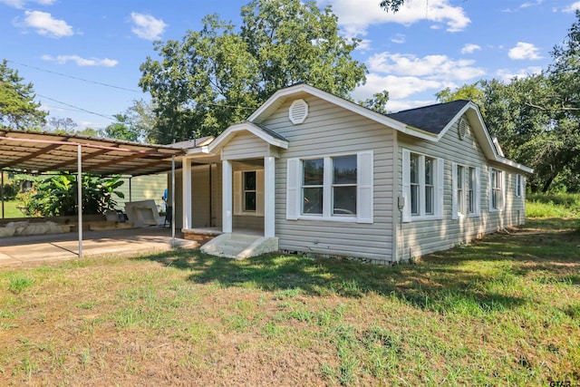 view of front facade featuring a carport and a front yard