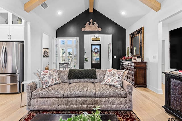 living room with beam ceiling, light wood-type flooring, and high vaulted ceiling