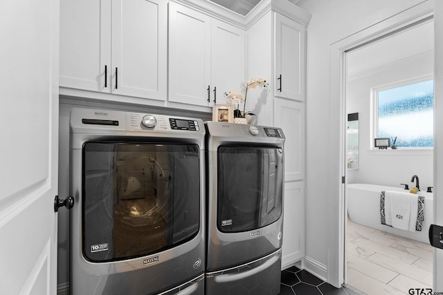 laundry area featuring washing machine and dryer and cabinets