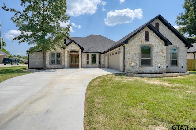 french country inspired facade with a garage, a front yard, and french doors