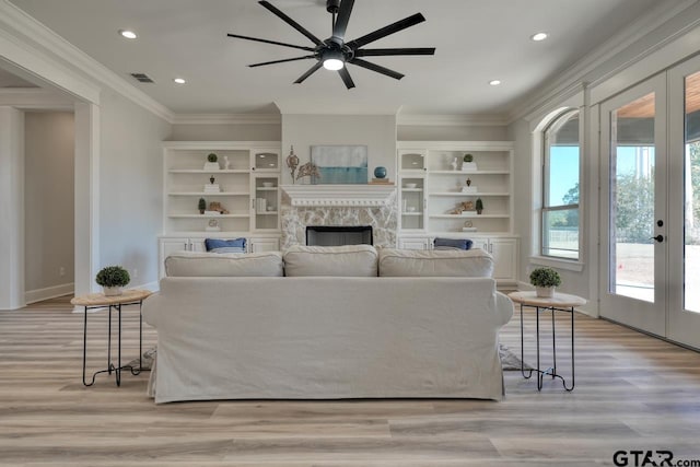 living room with ceiling fan, light hardwood / wood-style floors, ornamental molding, and french doors