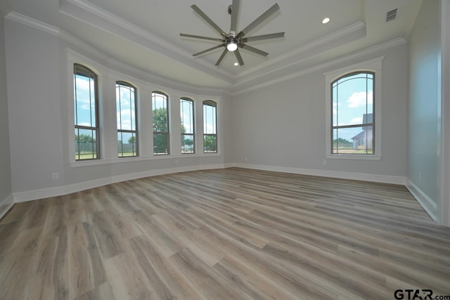 spare room with plenty of natural light, light wood-type flooring, and ornamental molding