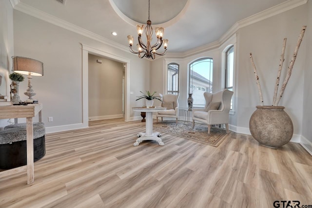 living area with a chandelier, crown molding, and light hardwood / wood-style floors