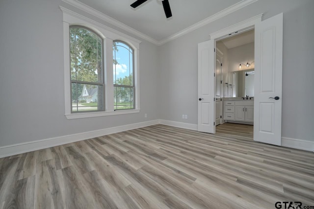 unfurnished bedroom featuring connected bathroom, light hardwood / wood-style flooring, ceiling fan, and ornamental molding