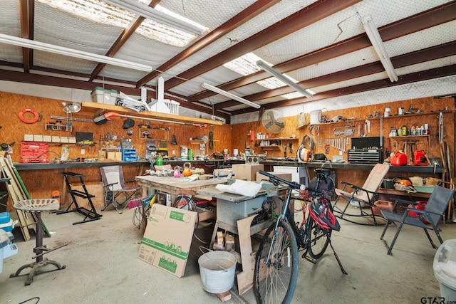 garage with a workshop area and wood walls