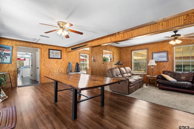 interior space featuring dark hardwood / wood-style flooring, wooden walls, and ceiling fan