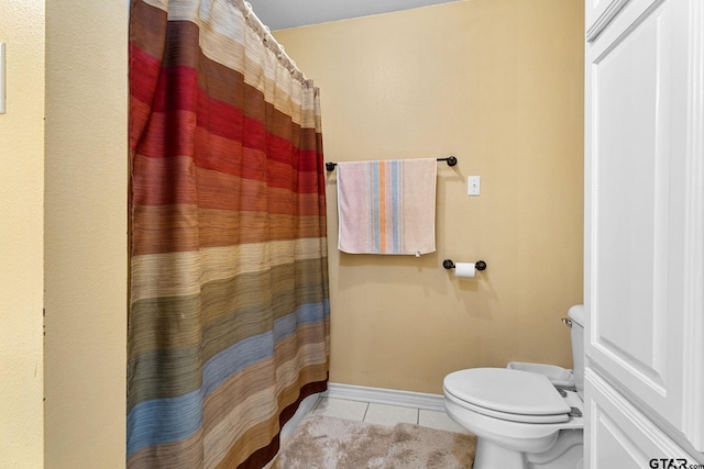 bathroom with toilet and tile patterned flooring