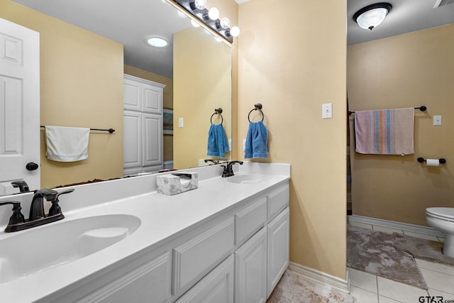 bathroom with tile patterned flooring, vanity, and toilet