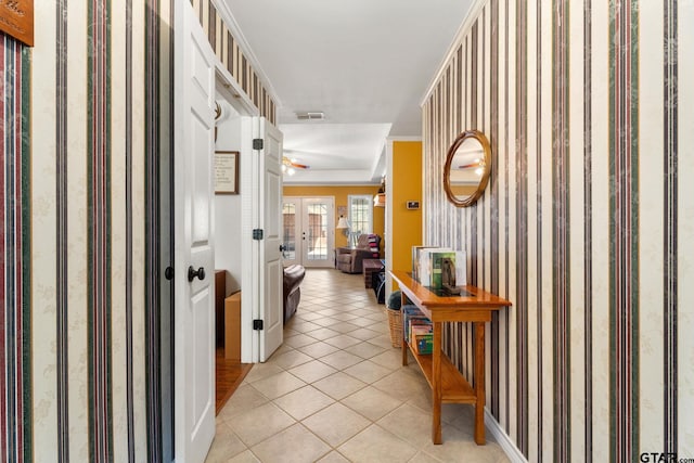 hall featuring crown molding and light tile patterned floors