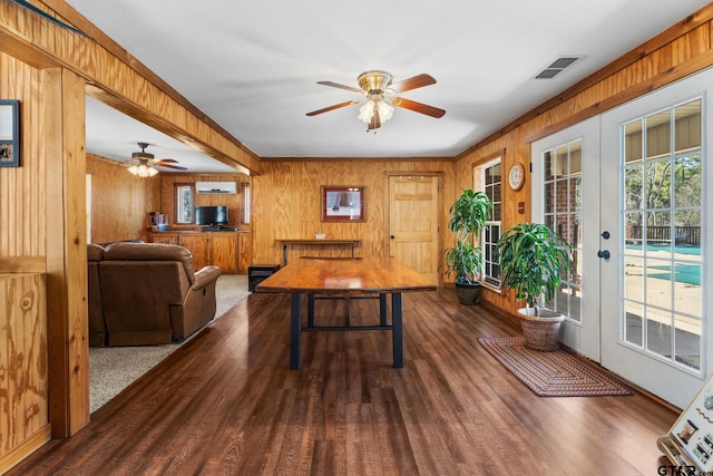 office area featuring dark hardwood / wood-style flooring, wood walls, ceiling fan, and french doors