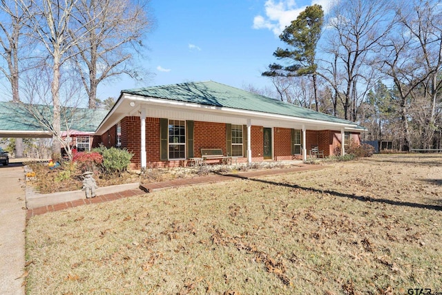 view of front facade with a front lawn, a carport, and covered porch