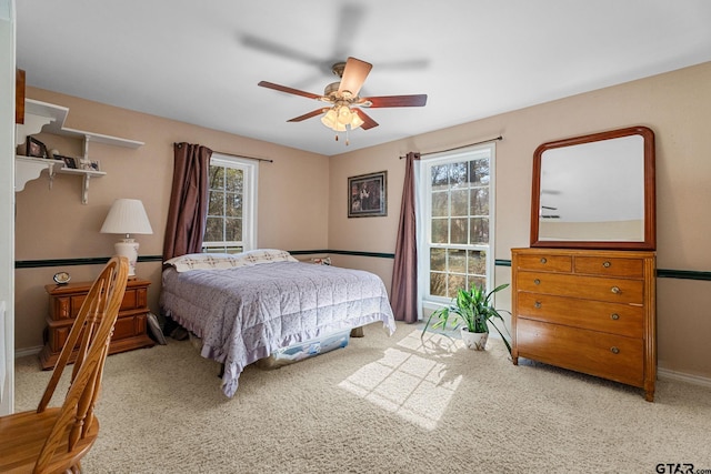 bedroom featuring multiple windows, ceiling fan, and carpet