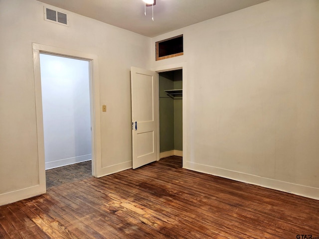 unfurnished bedroom with dark wood-type flooring and a closet