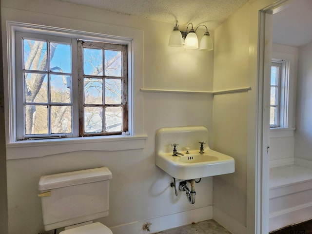 bathroom featuring a textured ceiling and toilet