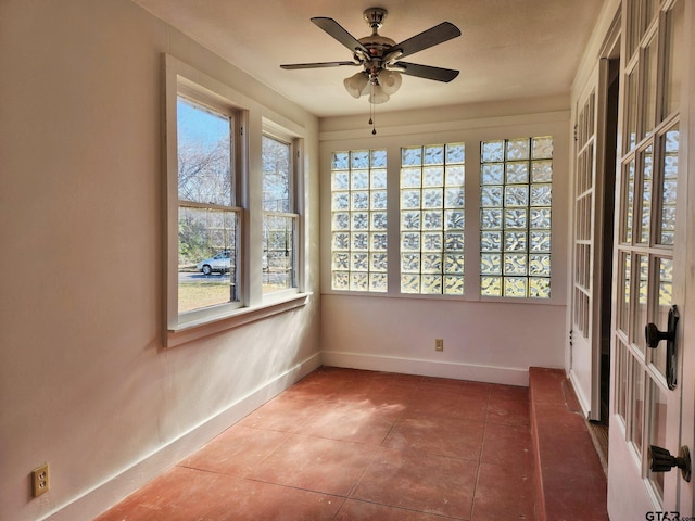 unfurnished sunroom with ceiling fan