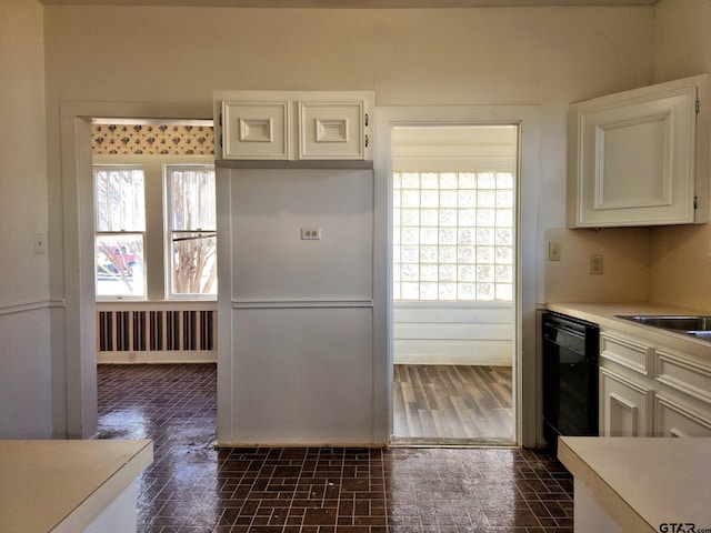 kitchen with dishwasher, radiator heating unit, a healthy amount of sunlight, and white cabinets