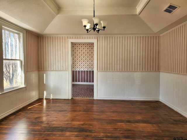 empty room with plenty of natural light, an inviting chandelier, dark hardwood / wood-style flooring, and a tray ceiling