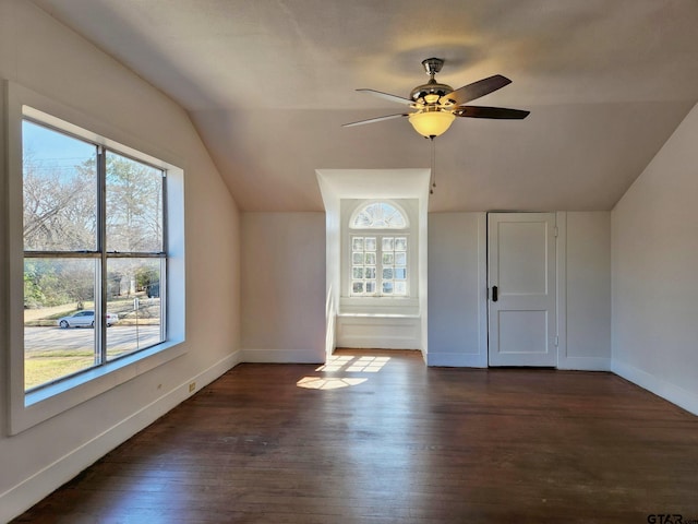 bonus room featuring plenty of natural light, lofted ceiling, dark wood-type flooring, and ceiling fan