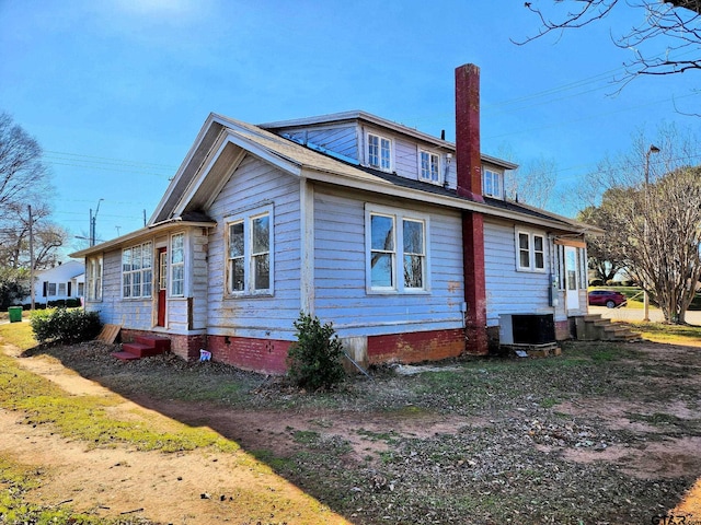 501 E Park Ave, Palestine, TX 75801 - view of side of home featuring entry steps, cooling unit, and a chimney