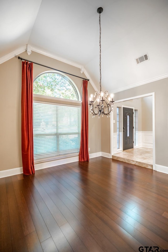 unfurnished dining area featuring ornamental molding, vaulted ceiling, and dark wood-type flooring