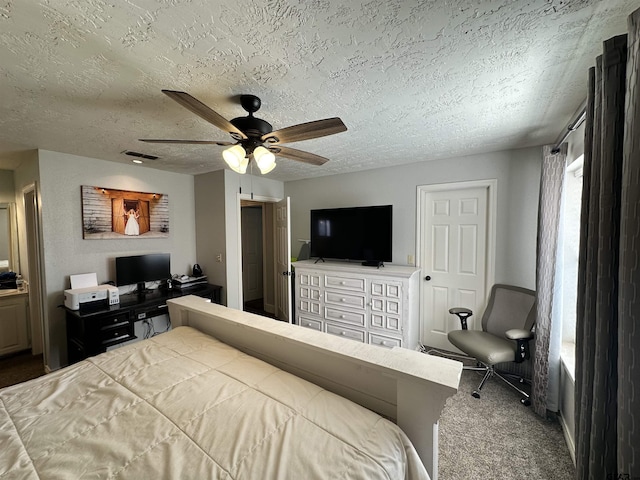 carpeted bedroom featuring ceiling fan and a textured ceiling