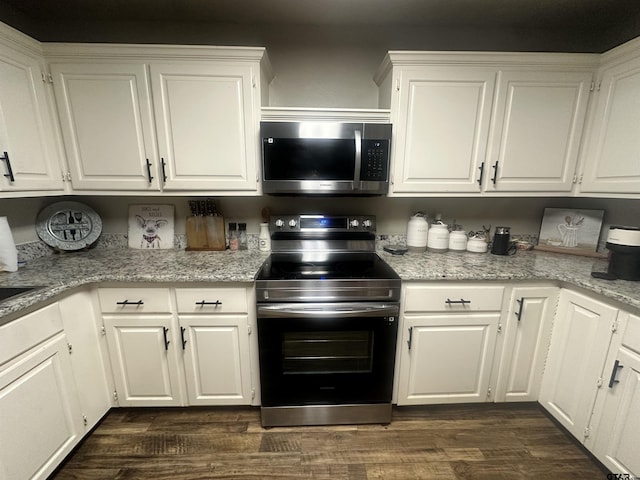 kitchen with stainless steel appliances, dark wood-type flooring, white cabinets, and light stone counters