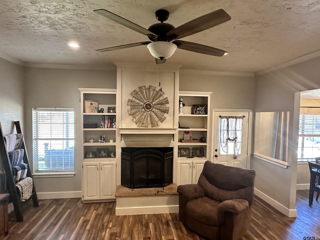 living area with crown molding, ceiling fan, a textured ceiling, and dark hardwood / wood-style flooring