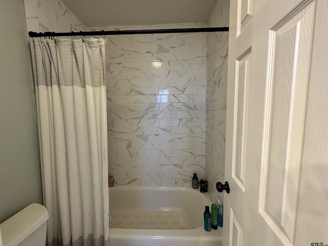 bathroom with shower / tub combo with curtain and toilet